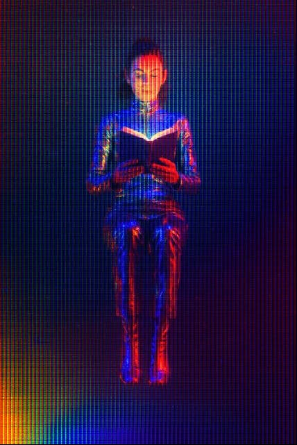 A futuristic woman reading a book.